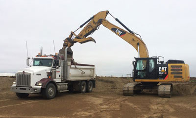 excavator emptying dirt into truck